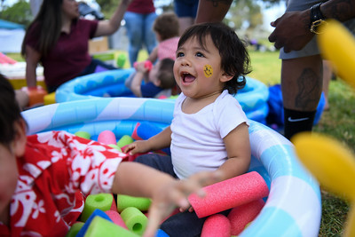 A child smiling in a soft sponge play pool. 