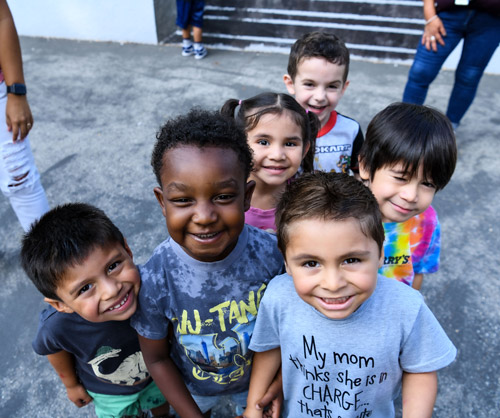 A group of children smiling together at a Head Start school.