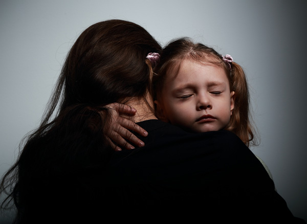 A sad daughter hugging her mother.